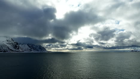 clouded sky over winter mountain and serene ocean in lofoten islands, norway wide shot