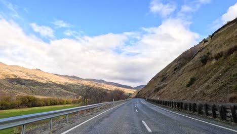 a picturesque journey through new zealand's mountainous landscapes, showcasing vibrant autumn foliage and expansive skies under natural lighting
