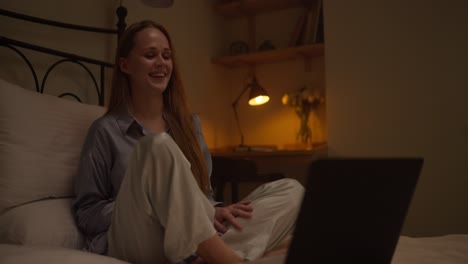 mujer trabajando en la computadora portátil en la cama por la noche