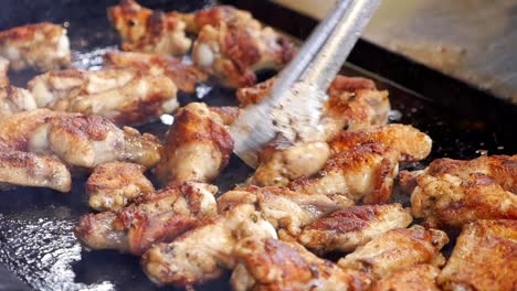 cerca de las alas de pollo siendo asadas en una parrilla plana de arriba