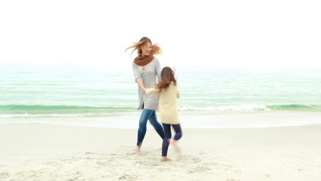 madre e hija jugando en la playa