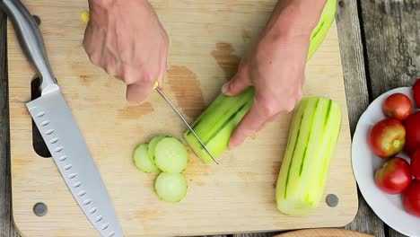 rebanar pepino en una tabla de cortar para ensaladera metrajes