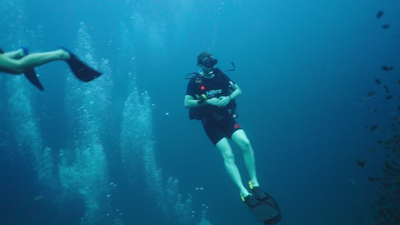 Scuba Diver Exploring an Underwater Coral Reef with Schools of Fish