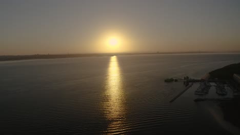 espectacular puesta de sol con cielo naranja en un día soleado sobre el río con setubal en segundo plano