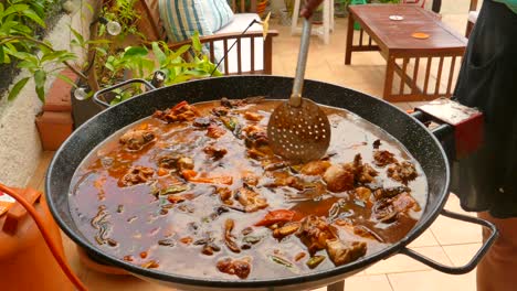 Primer-Plano-De-La-Elaboración-Tradicional-De-Paella-Cocinada-En-Una-Estufa-De-Gas-En-Valencia,-España,-Durante-El-Día.