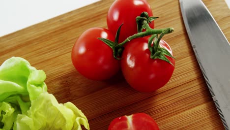 vegetables and kitchen knife on chopping board