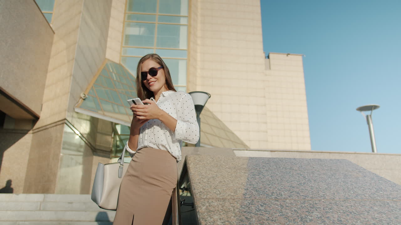 Businesswoman using smartphone outside office building