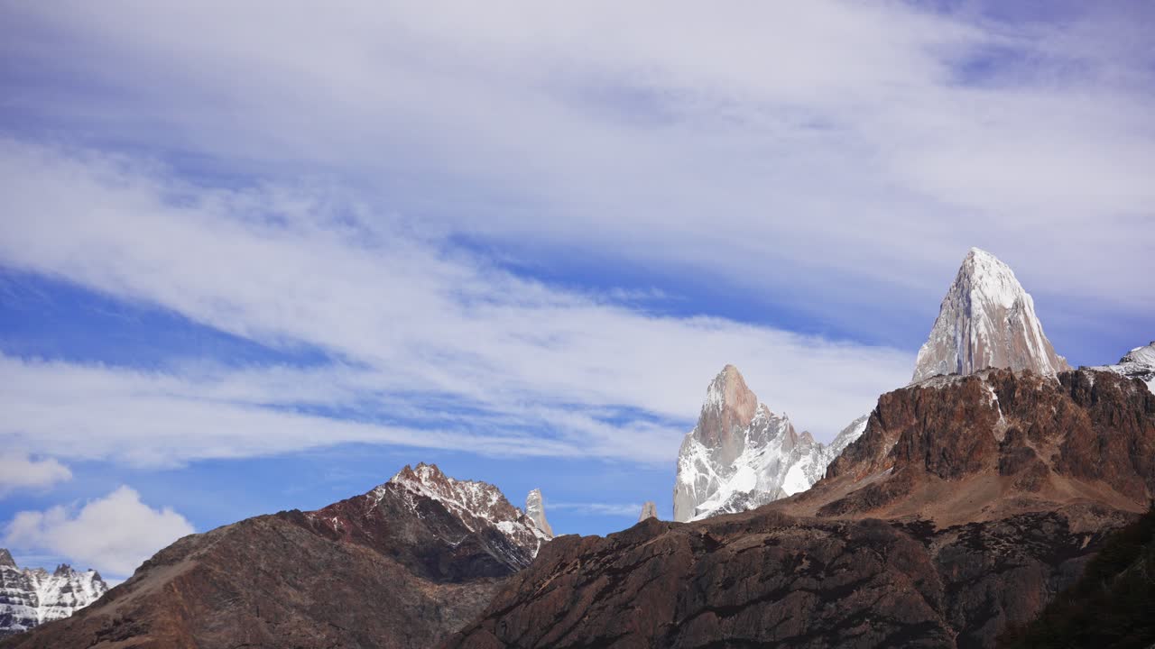 Snow covered granite peaks of Fitz Roy and Poincenot under drifting clouds. Patagonia, Argentina. Timelapse