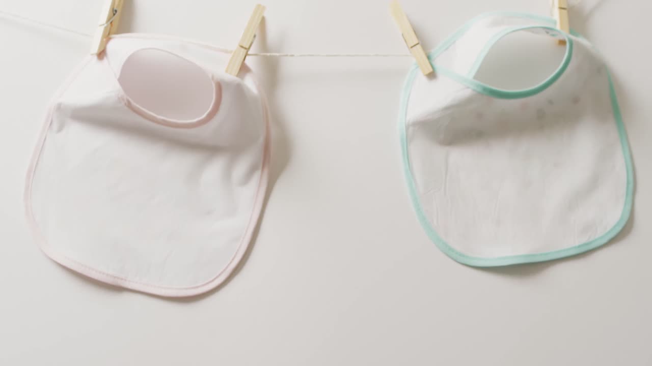 video de primer plano de dos babysitters blancos con clavijas colgando en un fondo blanco.