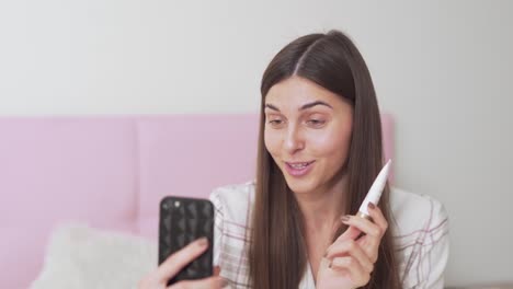 hermosa chica hablando por teléfono en las redes sociales sobre crema para los ojos