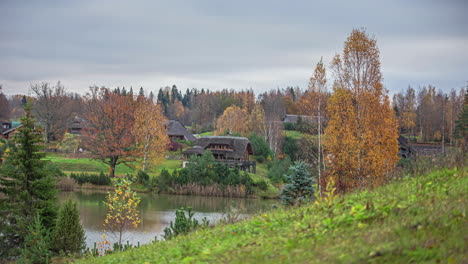 Timelapse-shot-of-warm-autumn-day-in-rural-countryside-with-view-of-beautiful-cottages-by-the-side-of-a-lake