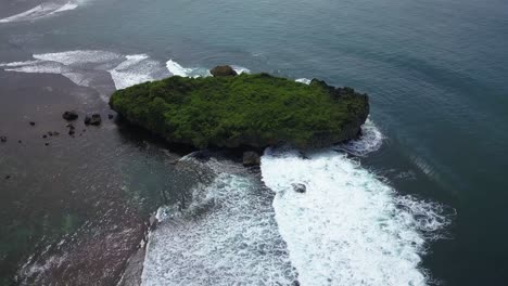 aerial view of tropical beach with blue water and waves crashing coral rock