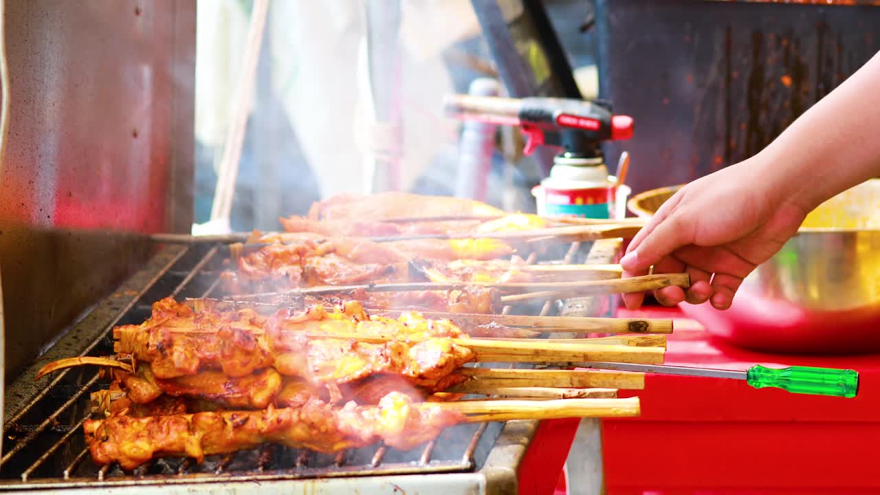 판매자 가 시장 상점 에서 고기 스피어 를 고 있다