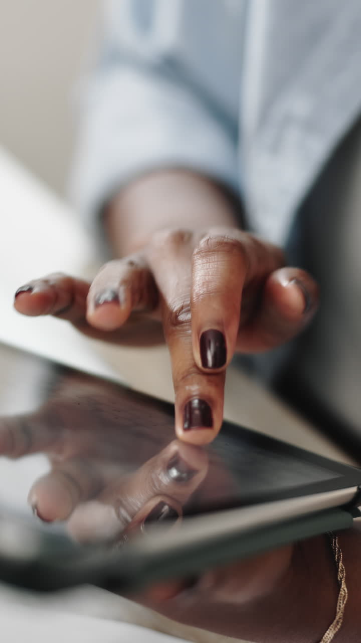 Primo piano di una mano che tocca e scorre su un tablet digitale.