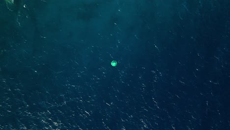 dron aéreo de arriba hacia abajo de la boya en el agua del océano de gradiente verde azul abierto