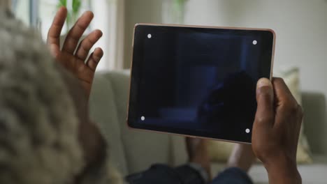 video of african american senior man using tablet with black screen