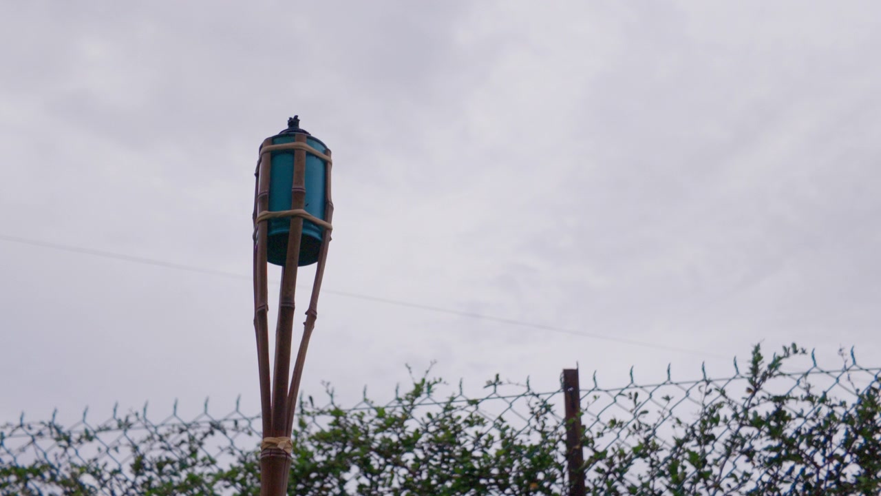 4K slow-mo static close-up of an unlit traditional bamboo "pelita" oil lamp against an overcast sky in Melaka, Malaysia. Used for Ramadan and Eid.