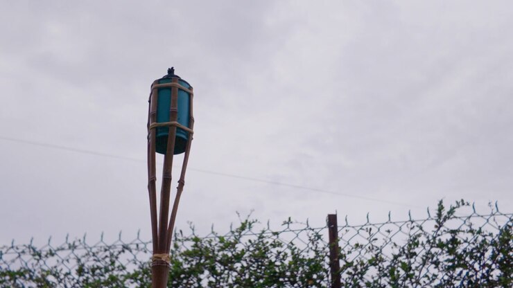 4K slow-mo static close-up of an unlit traditional bamboo "pelita" oil lamp against an overcast sky in Melaka, Malaysia. Used for Ramadan and Eid.