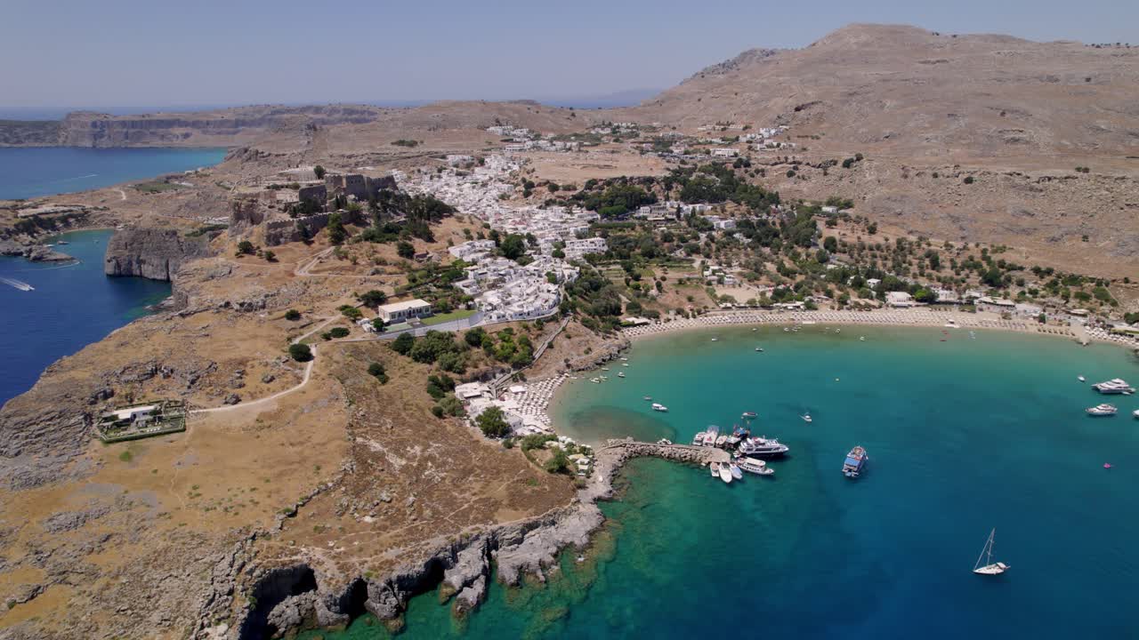 Aerial shot of Lindos showcasing white buildings and blue sea.