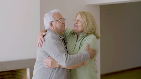 cheerful senior couple hugging after buying new house