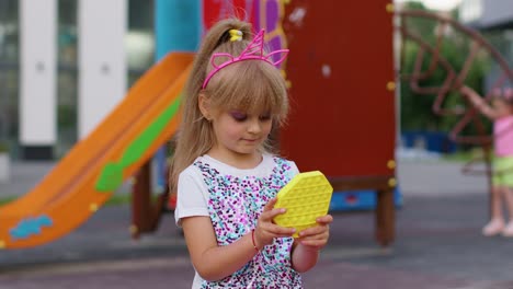 Children-girl-squeezing-presses-colorful-anti-stress-touch-screen-push-pop-it-popular-toy-in-park