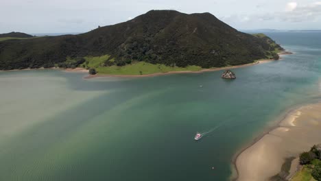 amazing houhora heads, peninsula coastal with boat cruising inlet from the ocean