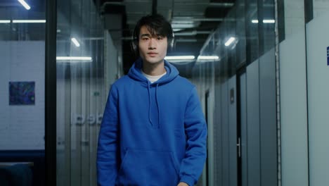 man wearing headphones in office corridor