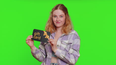 glückliche frau zeigt auf geschenk rabatt zertifikat gutschein coupon für den laden feiertage verkauf