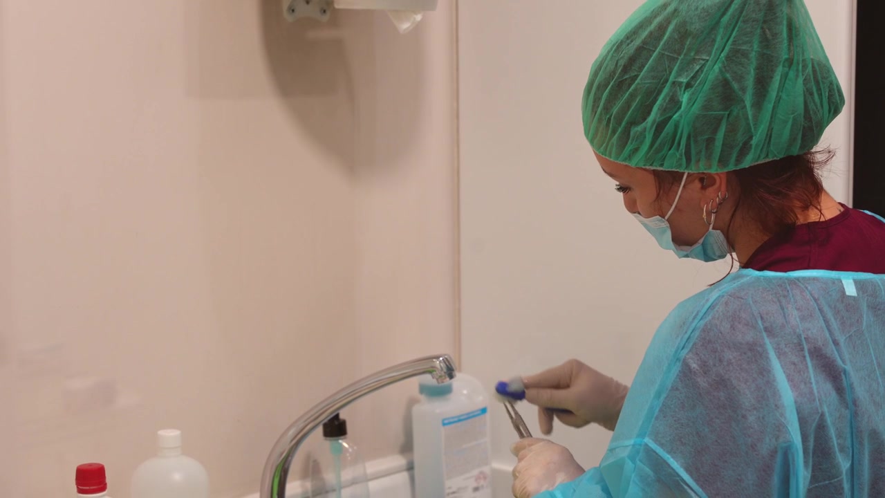 Assistente dentale che sterilizza attentamente gli strumenti per la procedura. Primo piano