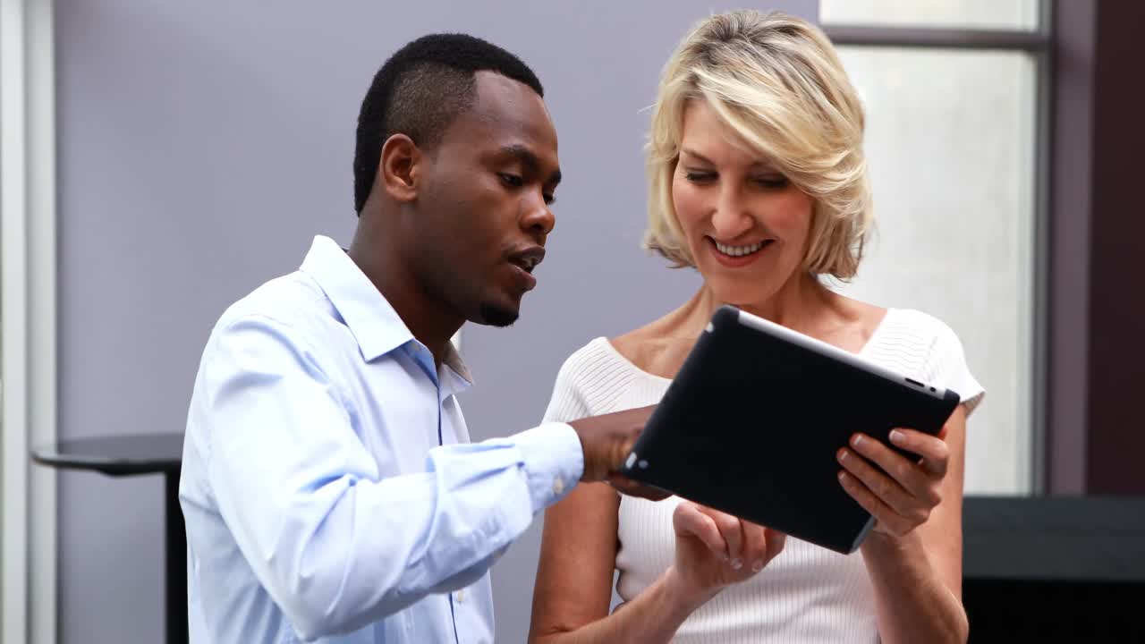 ejecutivos discutiendo sobre una tableta digital