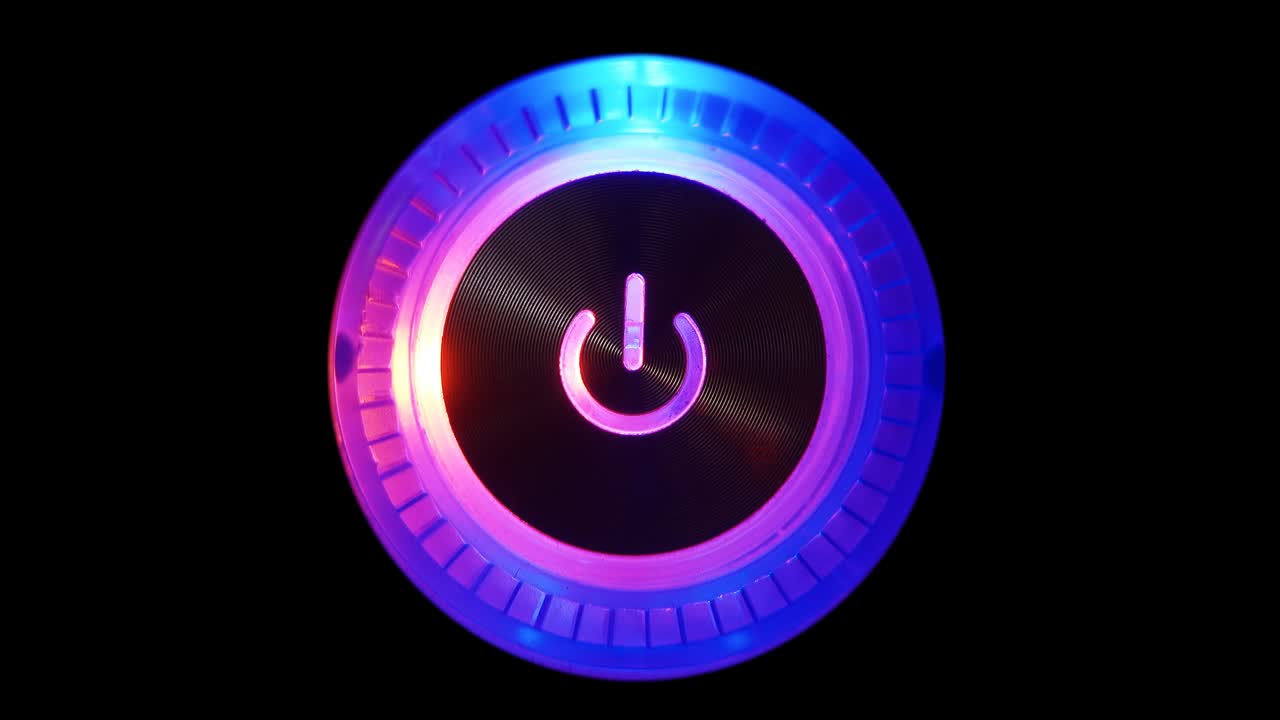 un bucle de video macro de 4k de un botón de encendido de la computadora en la unidad del sistema sobre un fondo negro.
