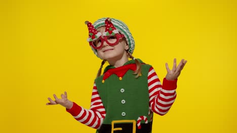 Kid-girl-in-Christmas-elf-Santa-helper-costume-dancing,-fooling-around.-New-Year-holiday-celebration