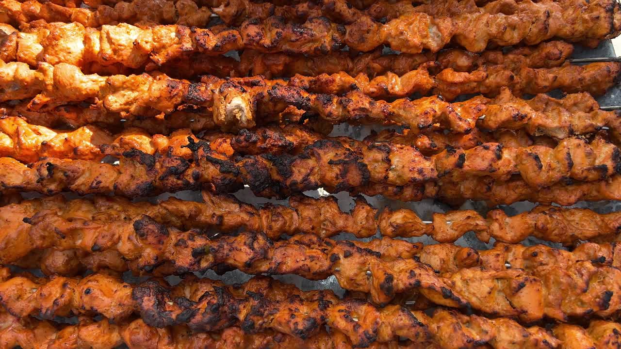 Skewers full of grilled kebab getting ready for guests.