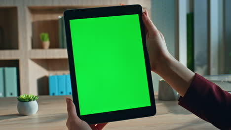 director reading mockup tablet report sitting office desk close up. female hands