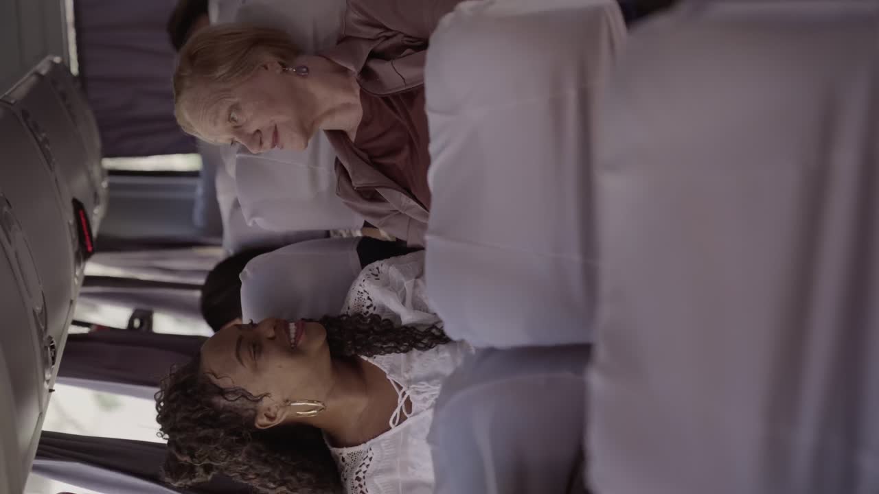 Two women sharing a joyful conversation on a bus