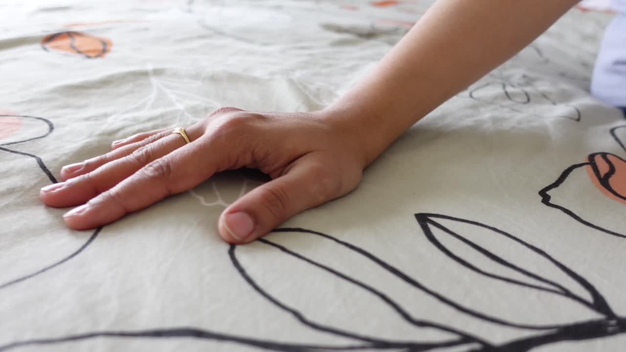Close-up of a Hand on Floral Bedding