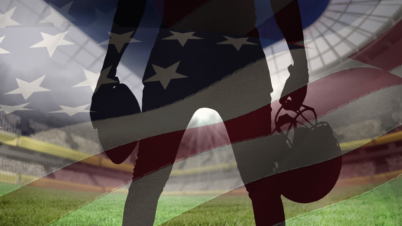 남자 럭비 선수 가 스포츠 경기장 을 상대로 공 과 헬 ⁇  을 들고 미국  ⁇ 발 을 흔들고 있다