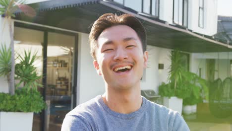 Video-of-happy-biracial-man-smiling-at-camera-in-backyard