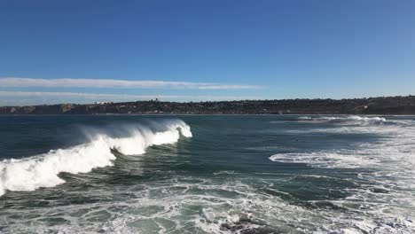 4k slow motion footage of large ocean waves crashing on cliffs at high tide in la jolla cove in san diego california as a pelicans fly by