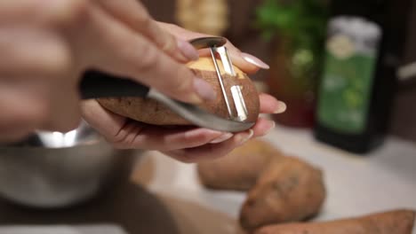 Female-Hands-Peeling-Peruvian-Ground-Apple-Using-Peeler