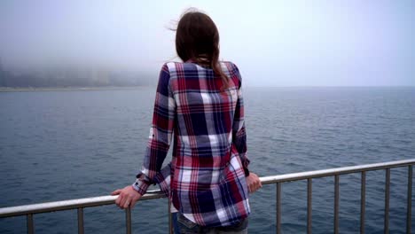 Calm-woman-back-looking-sea.-Back-view-of-woman-looking-on-fog-ocean