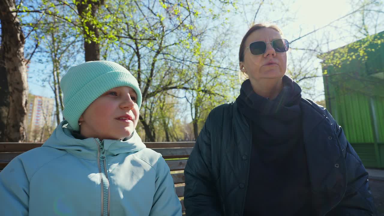 Güneşli Bir Günde Park Bankında Oturan Kadın ve Çocuk
