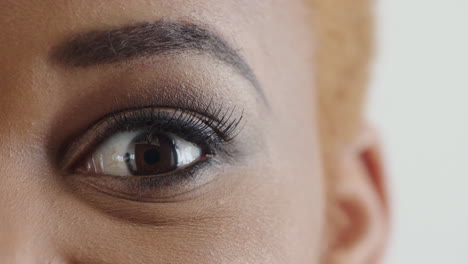 mujer afroamericana de cerca abriendo los ojos mirando sorprendida expresión asombrada belleza cosméticos fondo blanco