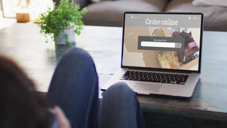 rodillas de una mujer en la mesa usando una computadora portátil, compras en línea de productos de belleza, cámara lenta