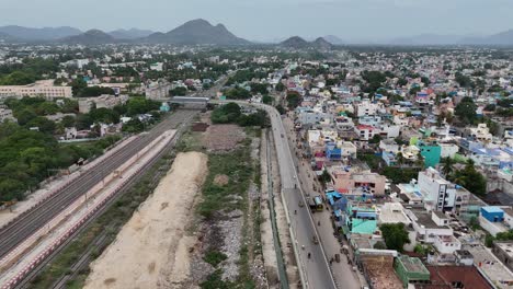 Toma-Aérea-De-Un-Dron-De-Una-Vía-De-Tren-Con-Un-Puente-Que-Pasa-Por-El-Tráfico