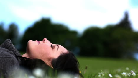 Mujer-Recostada-Sobre-El-Césped-En-Un-Parque