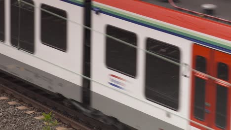 Tren-Acelerando-En-Las-Vías,-Capturando-La-Esencia-De-Los-Viajes-Y-El-Transporte-Modernos,-La-Luz-Del-Día