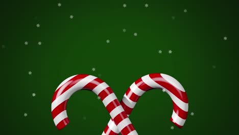 animación de dulces de navidad y nieve cayendo sobre un fondo verde