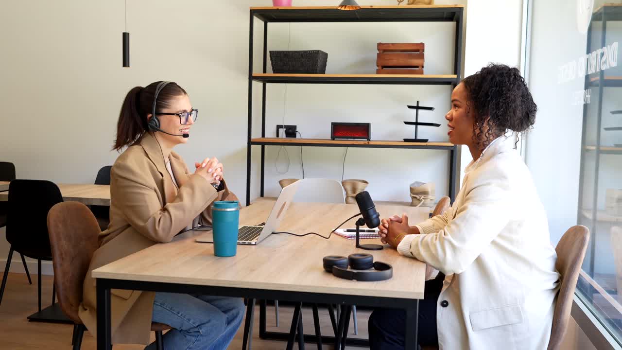 Two women recording a podcast interview in a modern office