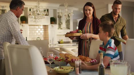 happy caucasian parents, children and grandfather preparing table for family meal